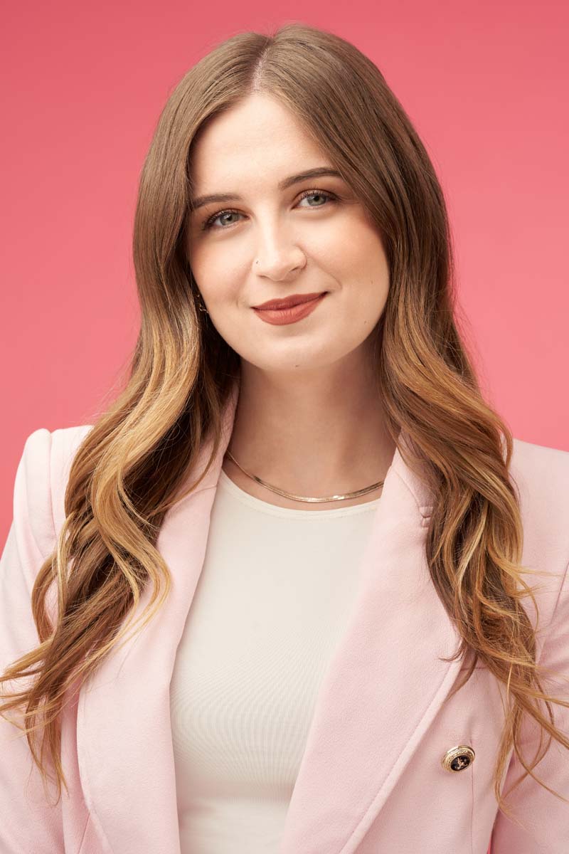 Smiling young woman professional headshot pink blazer NYC